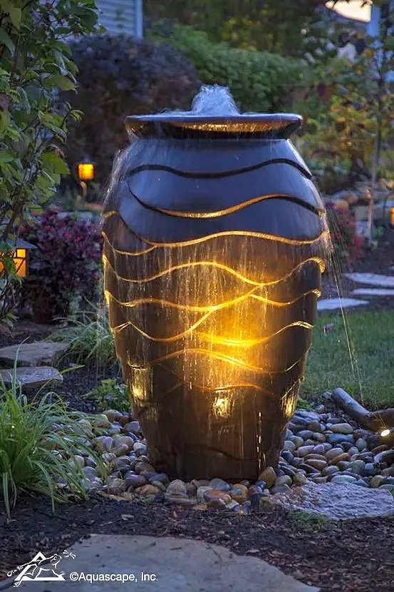 Scalloped urn fountain at night with lights